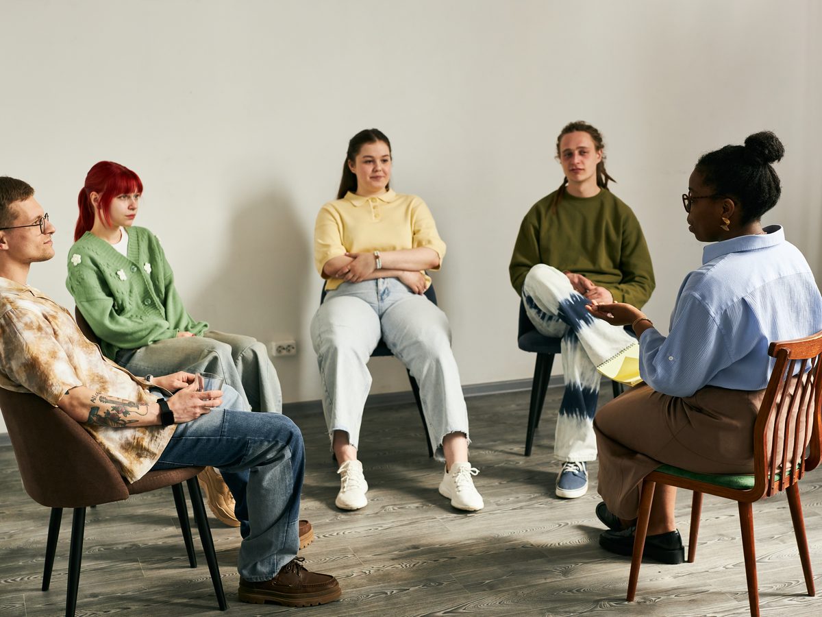 An indoor support group with adults seated together in conversation.