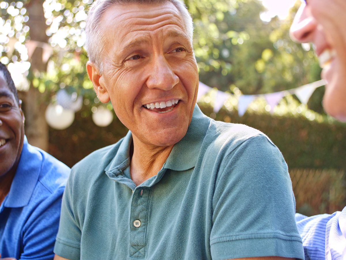 Older men sharing an unhurried conversation in a community space, faces relaxed.