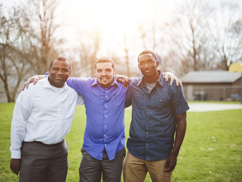 Three men outdoors, talking